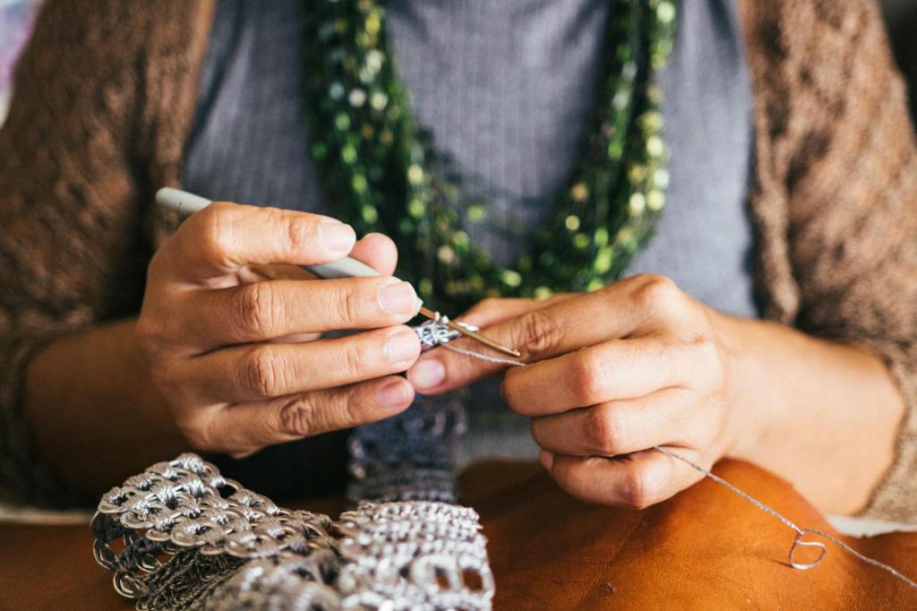 Close up of hands making jewelry.