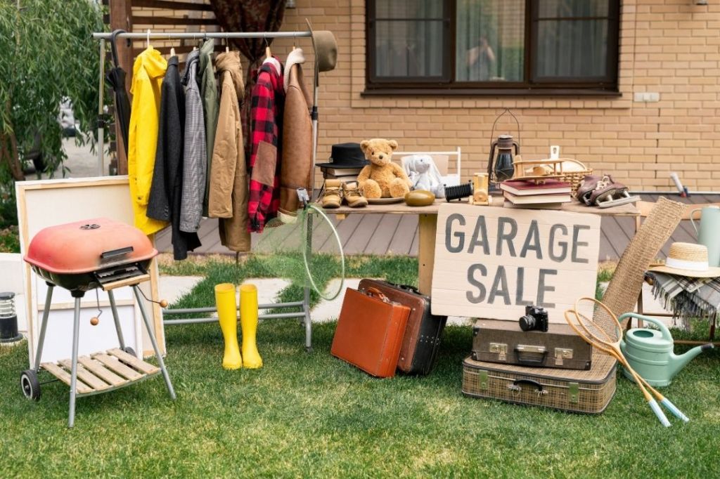 Items such as clothes, shoes, and gadgets for sale at a garage sale