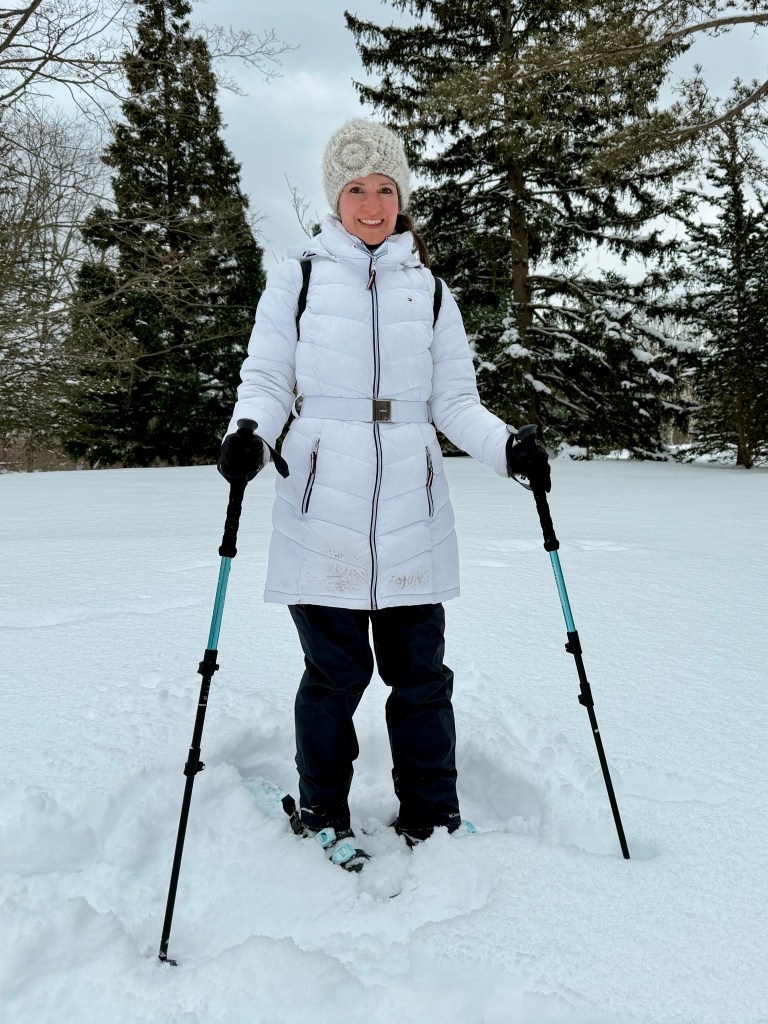 Lauren on snowshoes in an arboretum