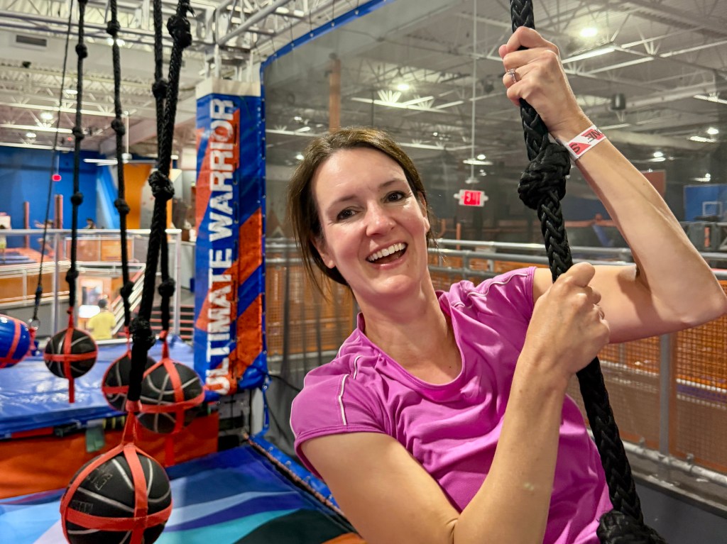 Lauren climbing a rope at the trampoline park.