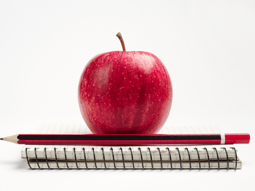 An apple sitting on top of a notebook